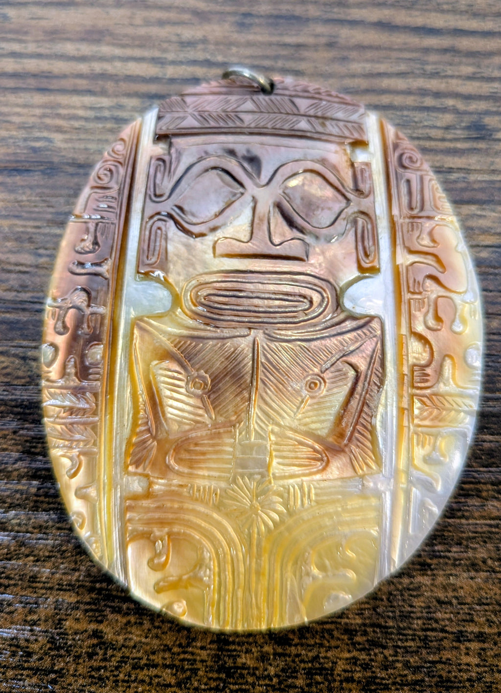 Large carved shell pendant with Mesoamerican figure design, 3 inches